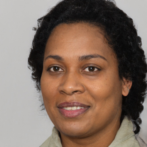 Joyful black adult female with long  brown hair and brown eyes