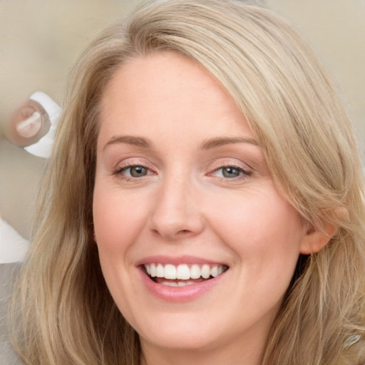 Joyful white young-adult female with long  brown hair and blue eyes