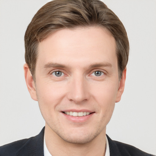 Joyful white young-adult male with short  brown hair and grey eyes