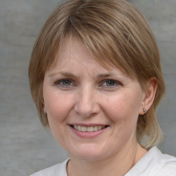 Joyful white adult female with medium  brown hair and blue eyes