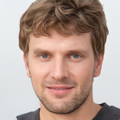 Joyful white young-adult male with short  brown hair and grey eyes