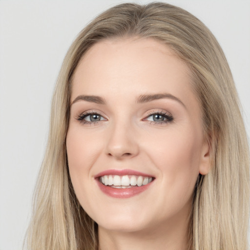 Joyful white young-adult female with long  brown hair and blue eyes