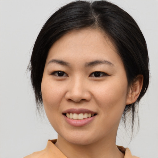Joyful asian young-adult female with medium  brown hair and brown eyes