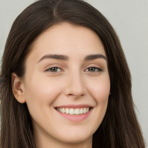 Joyful white young-adult female with long  brown hair and brown eyes