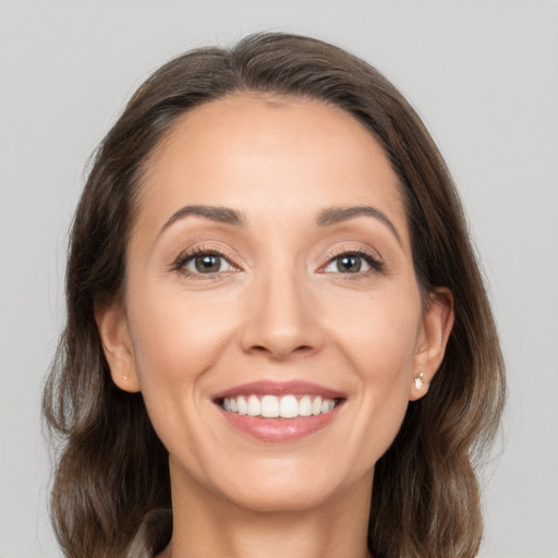 Joyful white young-adult female with medium  brown hair and grey eyes