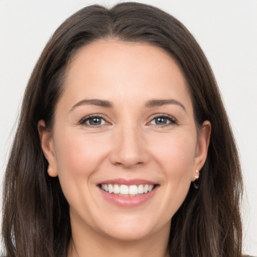 Joyful white young-adult female with long  brown hair and brown eyes