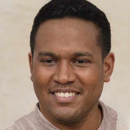 Joyful latino young-adult male with short  black hair and brown eyes