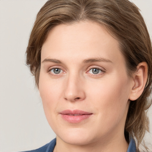 Joyful white young-adult female with medium  brown hair and blue eyes