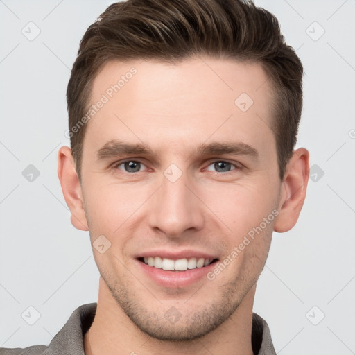 Joyful white young-adult male with short  brown hair and grey eyes