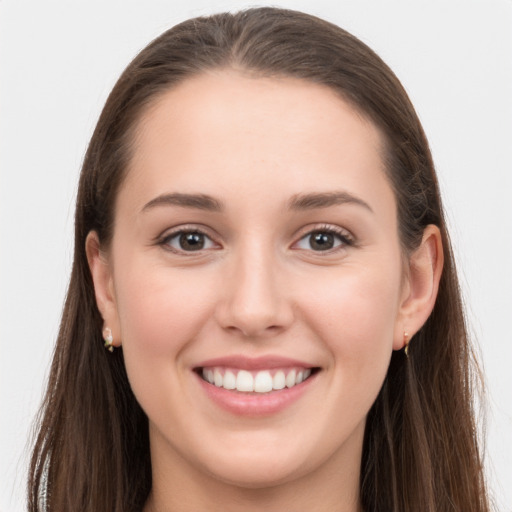 Joyful white young-adult female with long  brown hair and grey eyes