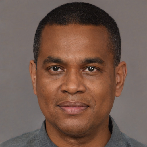 Joyful black adult male with short  brown hair and brown eyes