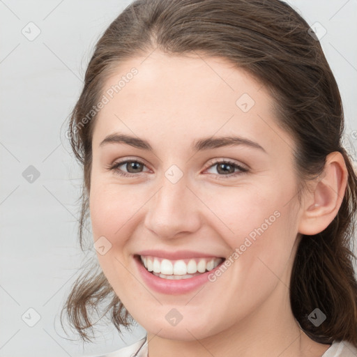 Joyful white young-adult female with medium  brown hair and grey eyes