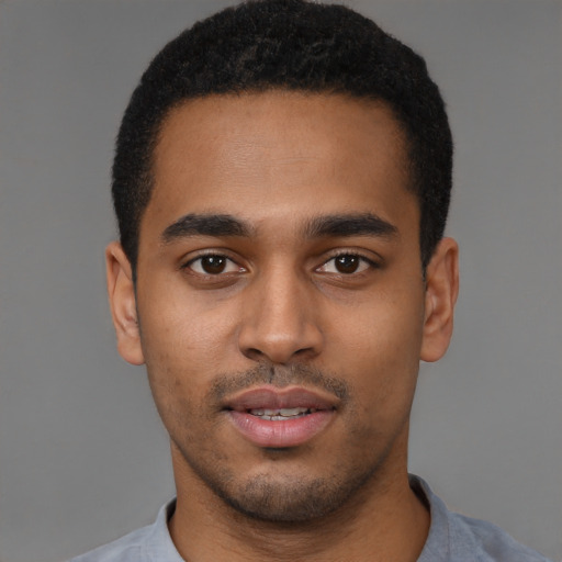 Joyful black young-adult male with short  black hair and brown eyes