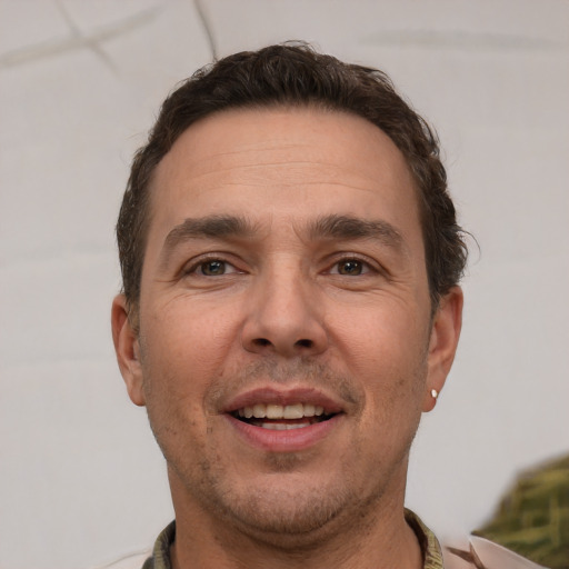 Joyful white adult male with short  brown hair and brown eyes