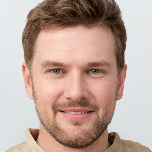 Joyful white young-adult male with short  brown hair and grey eyes