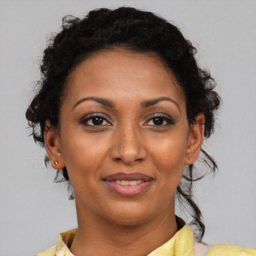 Joyful black young-adult female with short  brown hair and brown eyes