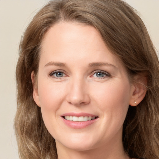 Joyful white adult female with long  brown hair and grey eyes