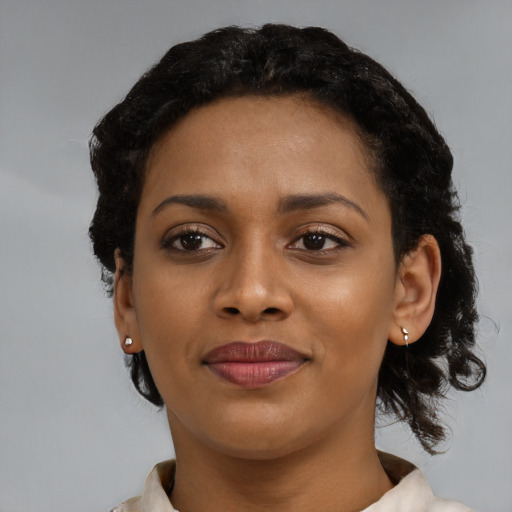 Joyful latino young-adult female with short  black hair and brown eyes