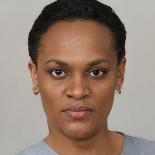 Joyful black young-adult female with short  black hair and brown eyes