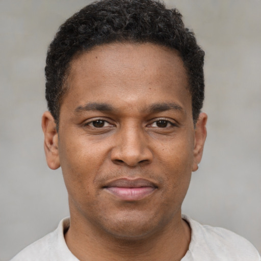 Joyful latino young-adult male with short  brown hair and brown eyes
