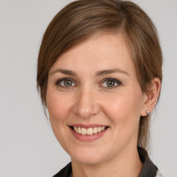 Joyful white young-adult female with medium  brown hair and grey eyes