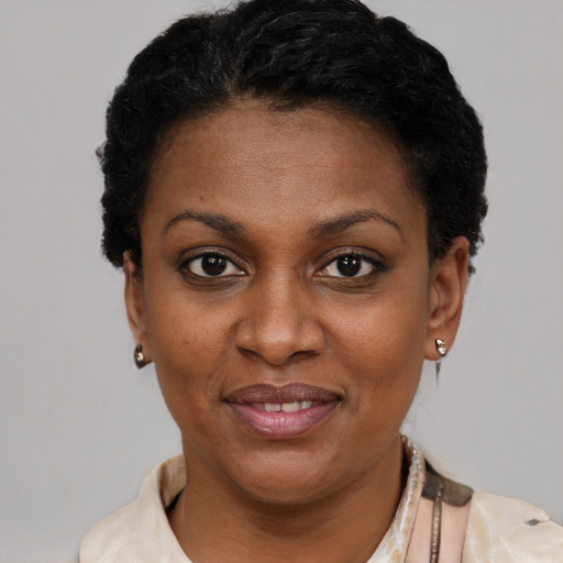 Joyful black young-adult female with short  black hair and brown eyes
