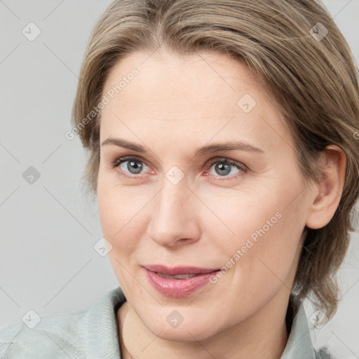 Joyful white adult female with medium  brown hair and blue eyes