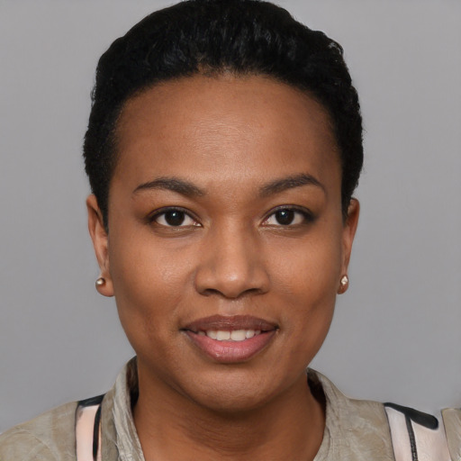 Joyful black young-adult female with short  black hair and brown eyes