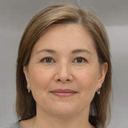 Joyful white adult female with medium  brown hair and grey eyes