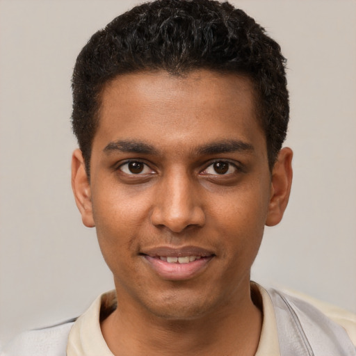 Joyful black young-adult male with short  brown hair and brown eyes