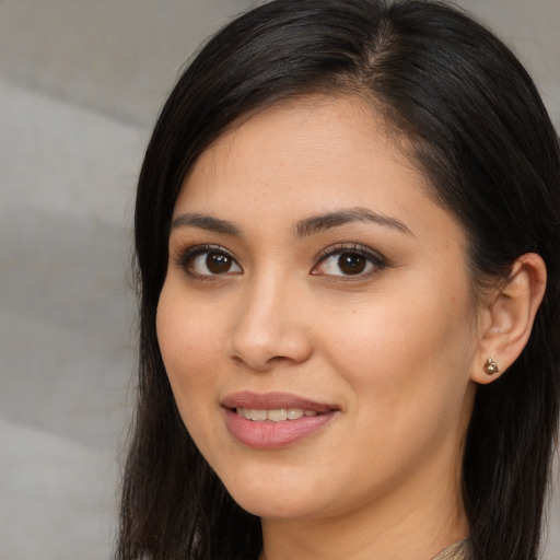 Joyful latino young-adult female with long  brown hair and brown eyes