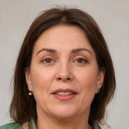 Joyful white adult female with medium  brown hair and green eyes