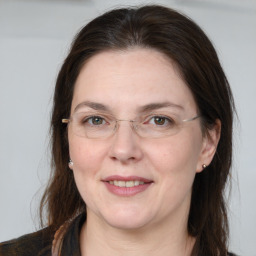 Joyful white adult female with medium  brown hair and grey eyes