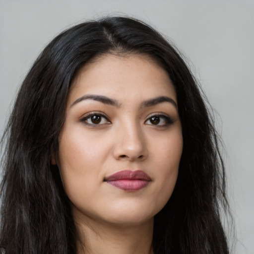 Joyful latino young-adult female with long  brown hair and brown eyes