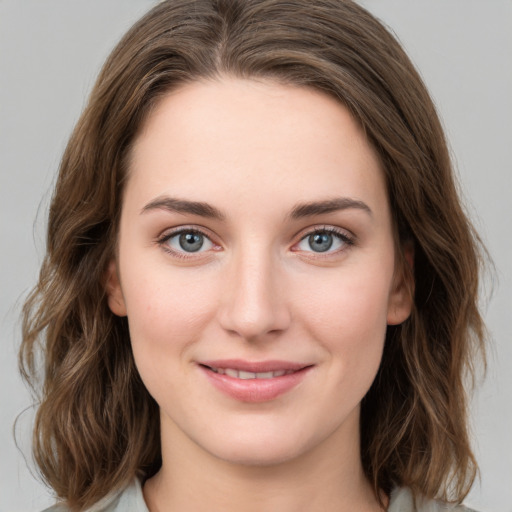 Joyful white young-adult female with medium  brown hair and green eyes