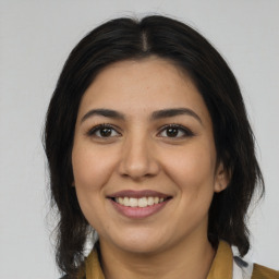 Joyful latino young-adult female with medium  brown hair and brown eyes