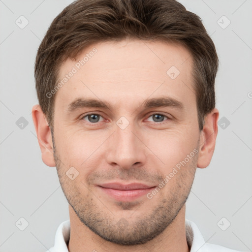 Joyful white young-adult male with short  brown hair and grey eyes