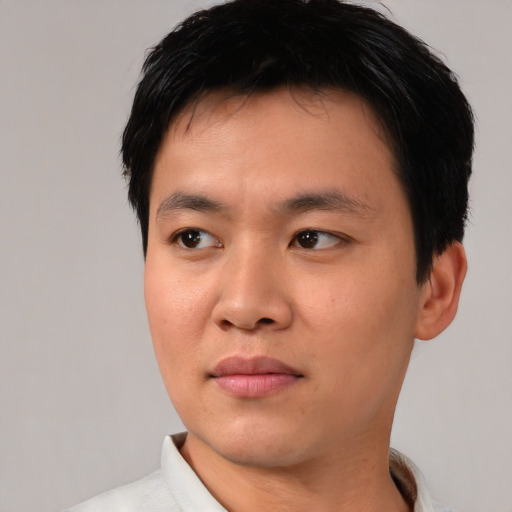 Joyful asian young-adult male with short  black hair and brown eyes