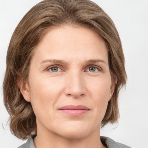 Joyful white adult female with medium  brown hair and grey eyes