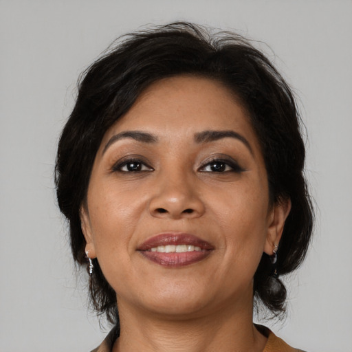 Joyful latino adult female with medium  brown hair and brown eyes