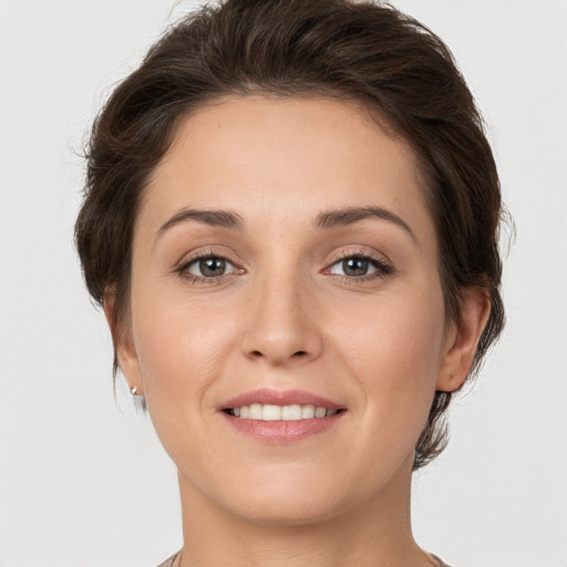 Joyful white young-adult female with medium  brown hair and grey eyes