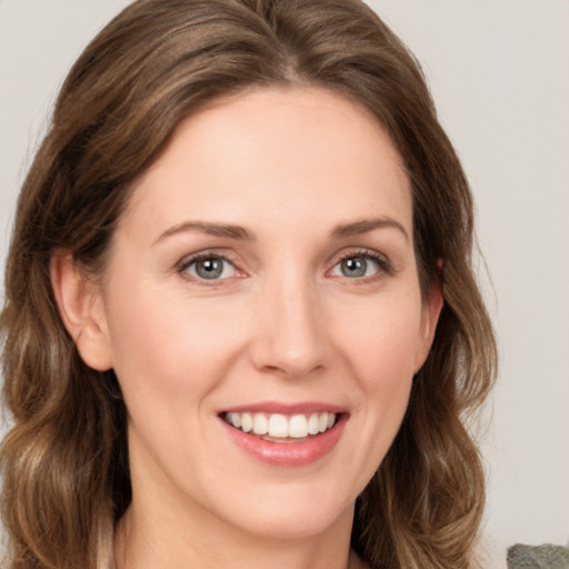 Joyful white young-adult female with medium  brown hair and green eyes