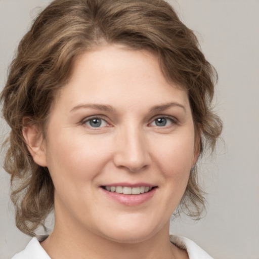 Joyful white young-adult female with medium  brown hair and grey eyes