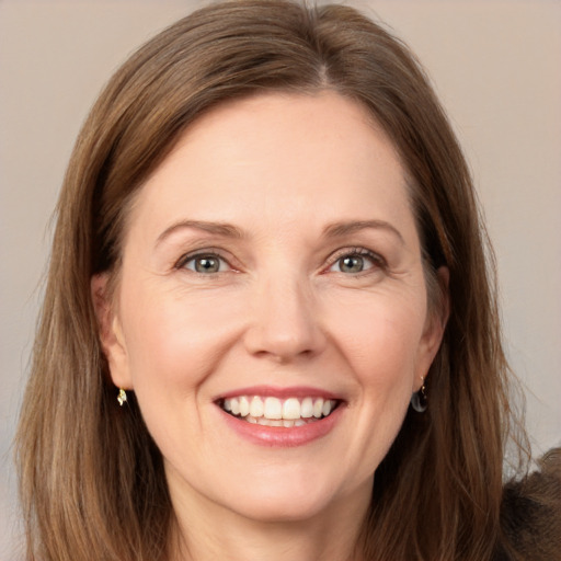 Joyful white adult female with long  brown hair and grey eyes