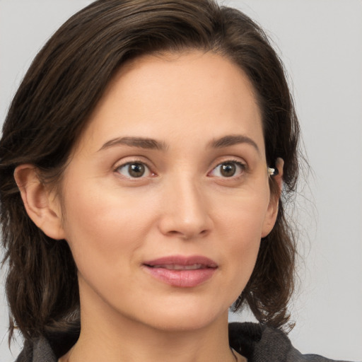 Joyful white young-adult female with medium  brown hair and grey eyes