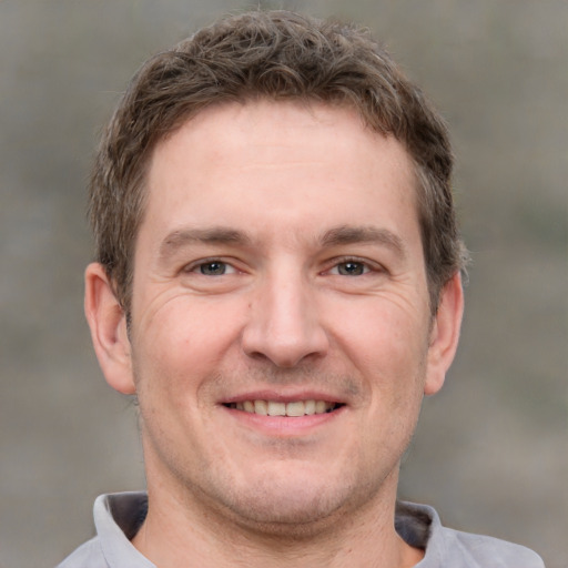 Joyful white adult male with short  brown hair and grey eyes