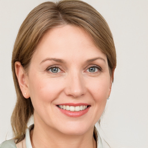 Joyful white young-adult female with medium  brown hair and blue eyes