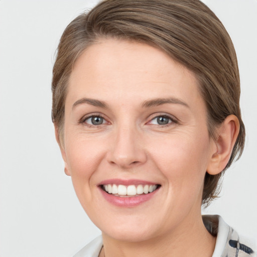 Joyful white young-adult female with medium  brown hair and grey eyes