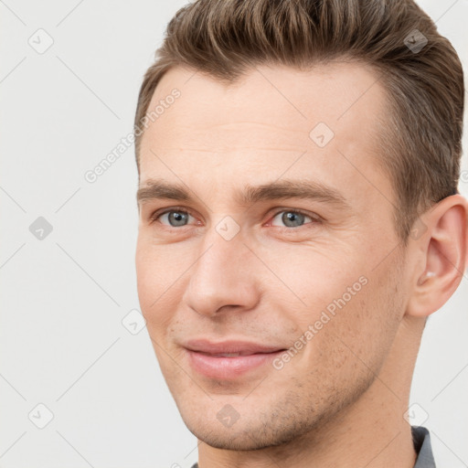 Joyful white young-adult male with short  brown hair and grey eyes