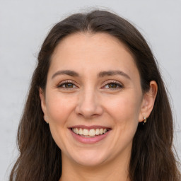 Joyful white adult female with long  brown hair and brown eyes